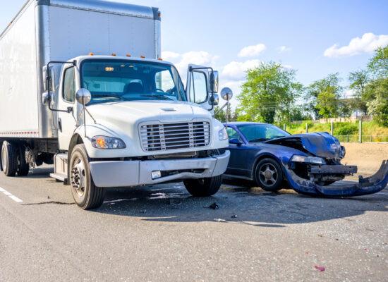 Collision of a semi truck with box trailer a passenger car on the highway road, as a result of which both cars were damaged, await the arrival of the police to draw up an accident report