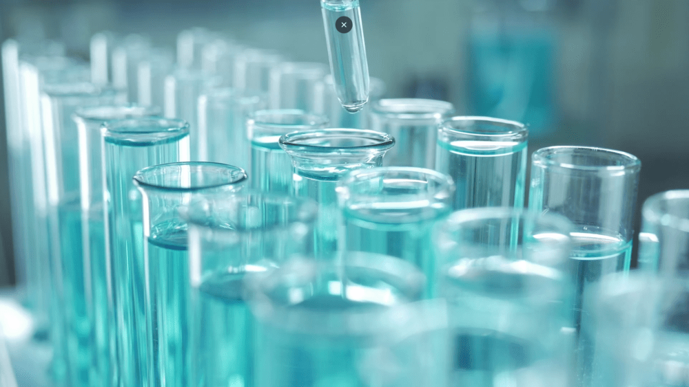 a scientist putting liquid into a pipette with a dropper