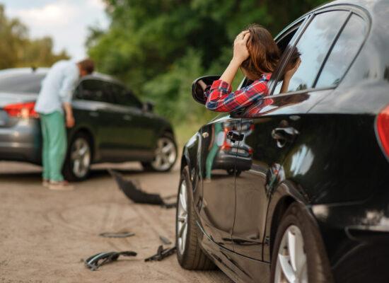 Male and female drivers after car accident on road. Automobile crash. Broken automobile or damaged vehicle, auto collision on highway