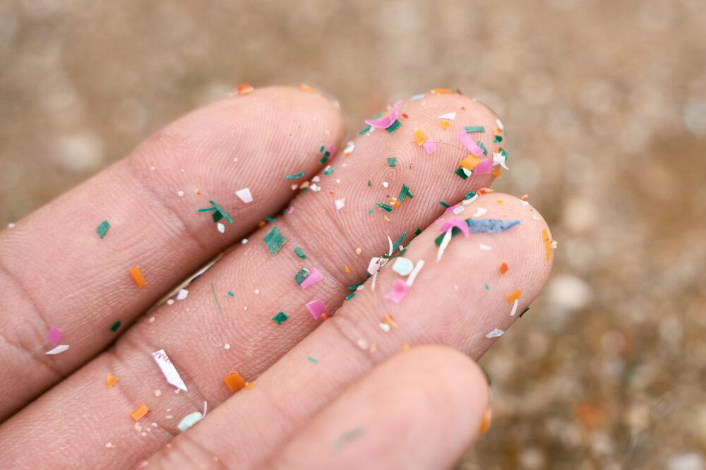 Close up side shot of microplastics on person's hand.