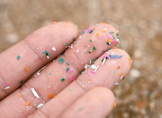 Close up side shot of microplastics on person's hand.