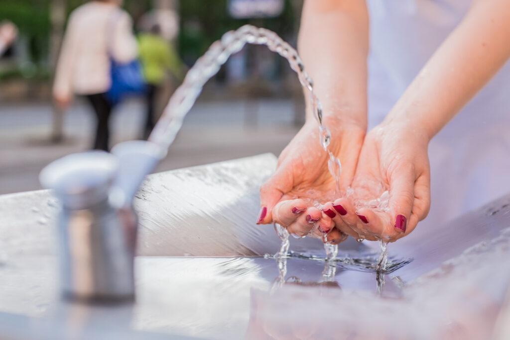 woman washing hands with public drinking water | Stag Liuzza a woman washing her hands using a public water drinking fountain