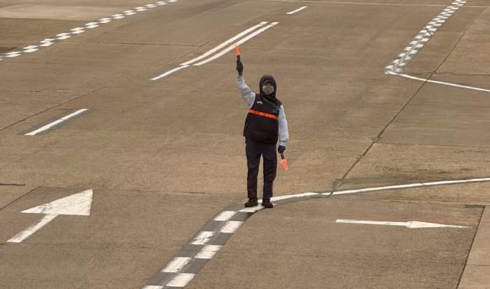 airport worker standing on a runway with lights