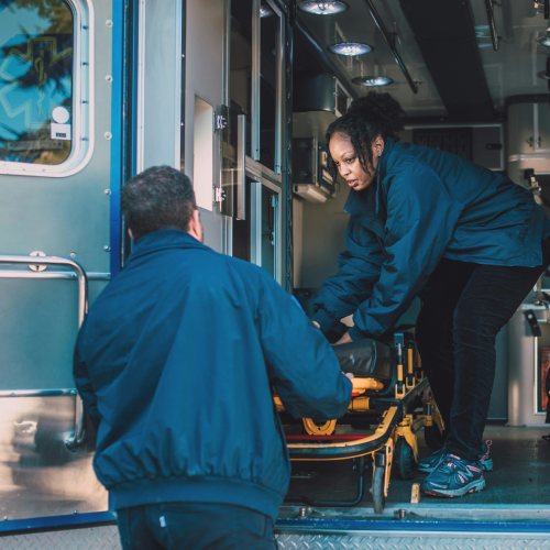 two paramedics working in the back of an ambulance