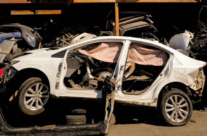 a crashed car all mangled up in a junk yard