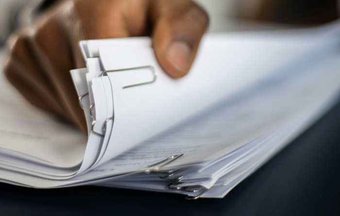 An attorney looking through a pile of evidence on a desk