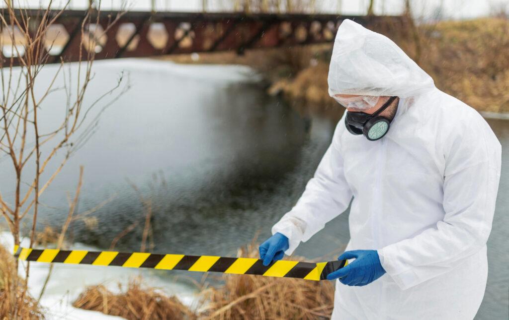 man in hazmat suit taping off an area contaminated by hazardous and radioactive materials