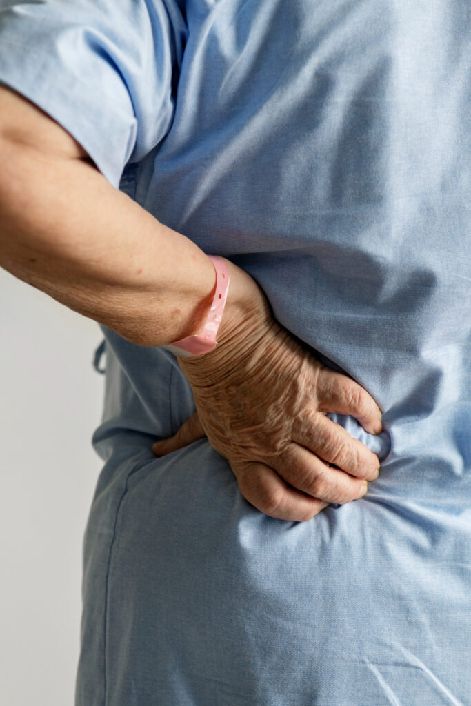 older patient holding their back following a hernia