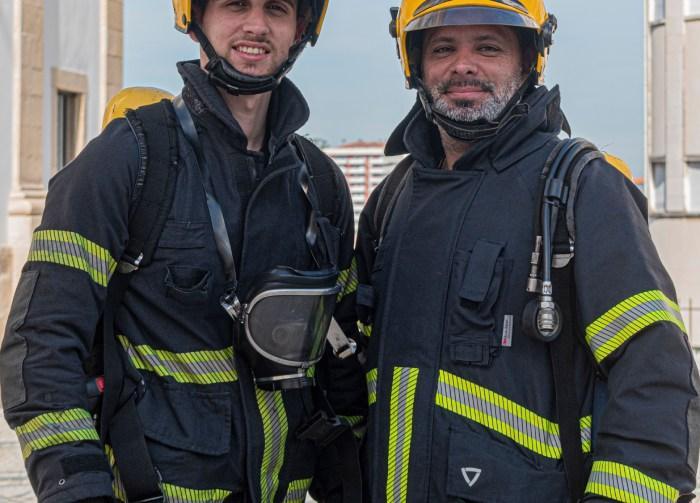 two firefighters stand together in their uniforms