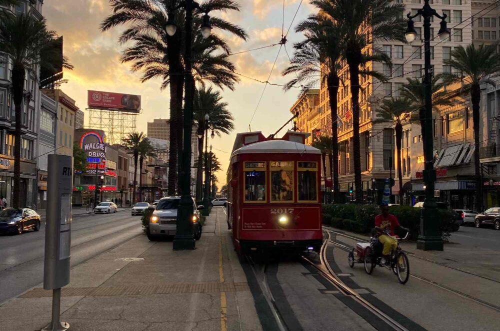 downtown new orleans louisiana at sunset with a trolley on tracks