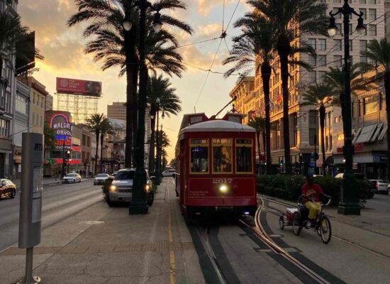 downtown new orleans louisiana at sunset with a trolley on tracks